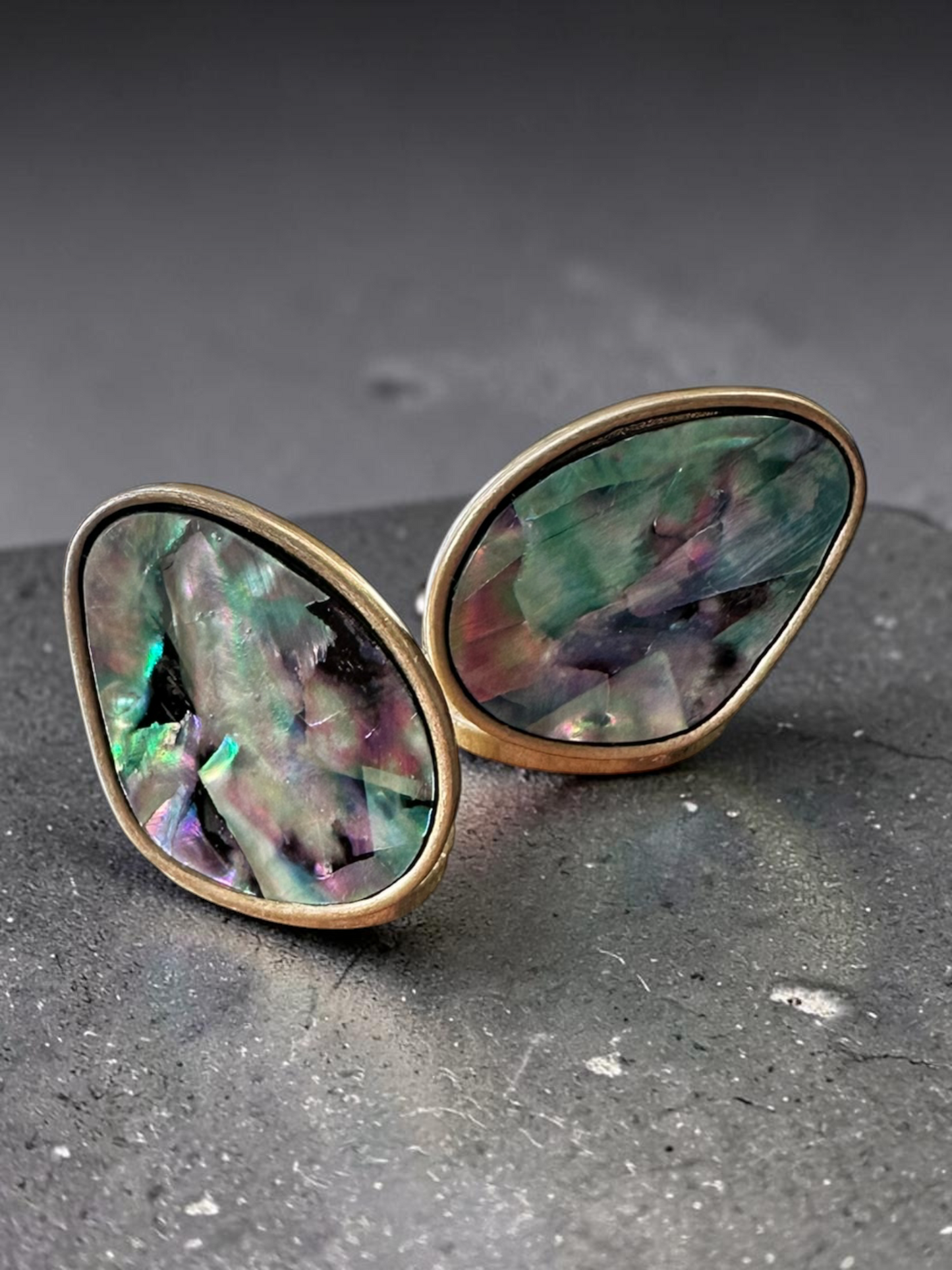 Vintage abalone shell oval stud earrings - angled view showing iridescence