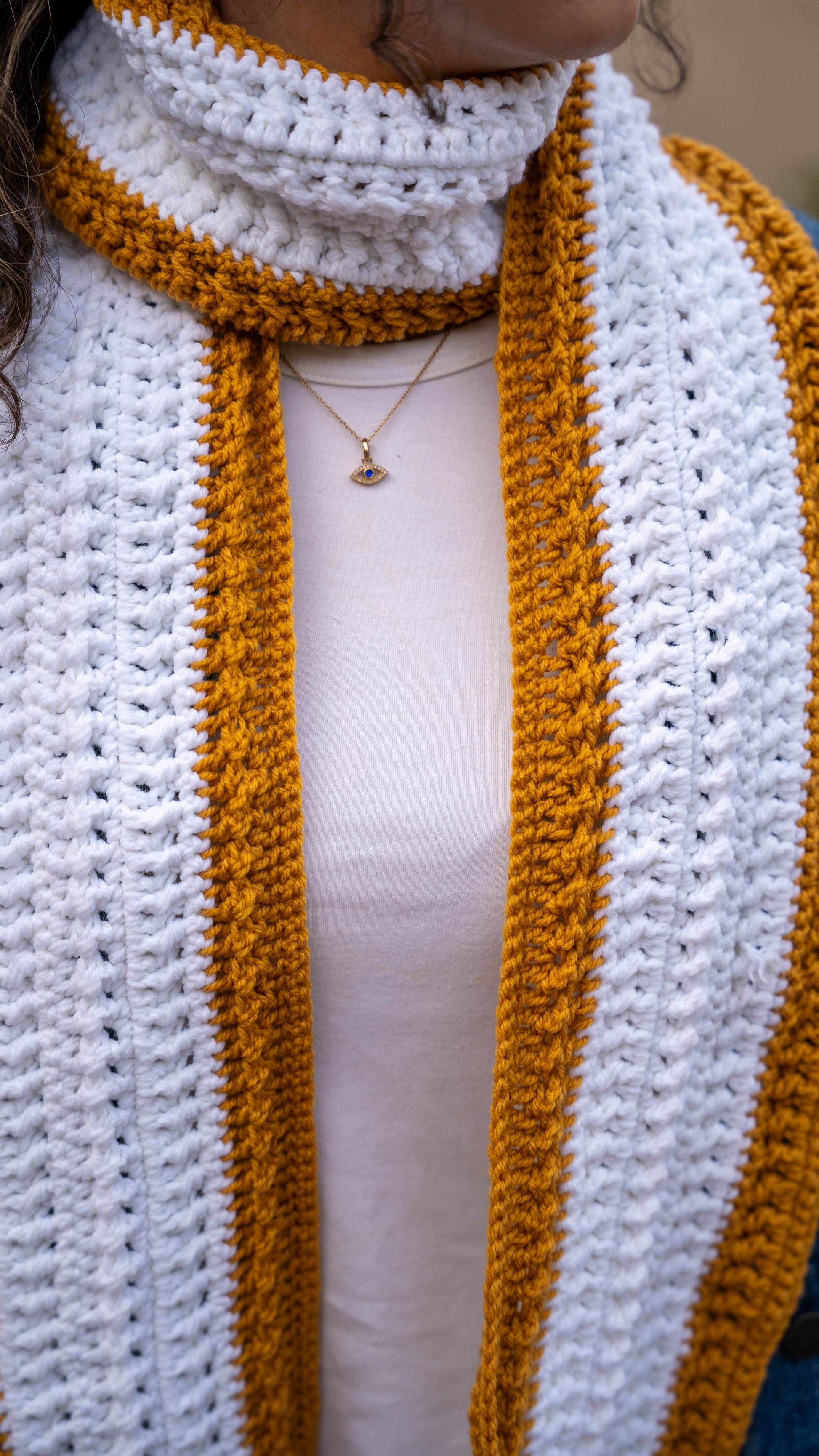 Close-up of mustard and white crochet scarf texture