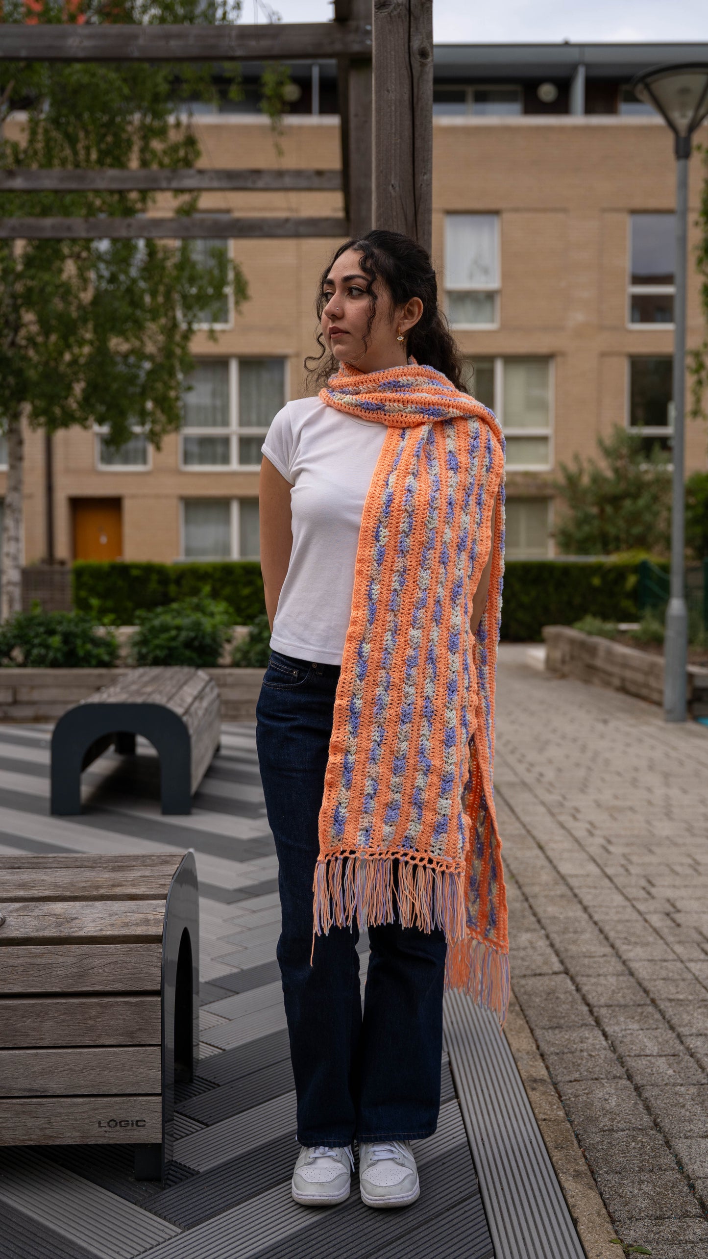 Model wearing peach and lilac crochet scarf, full length front view