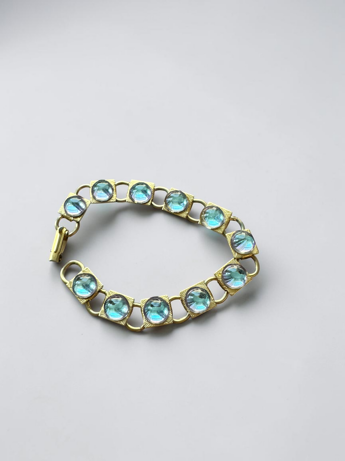 Vintage aqua glass cabochon gold tone link bracelet, circular view