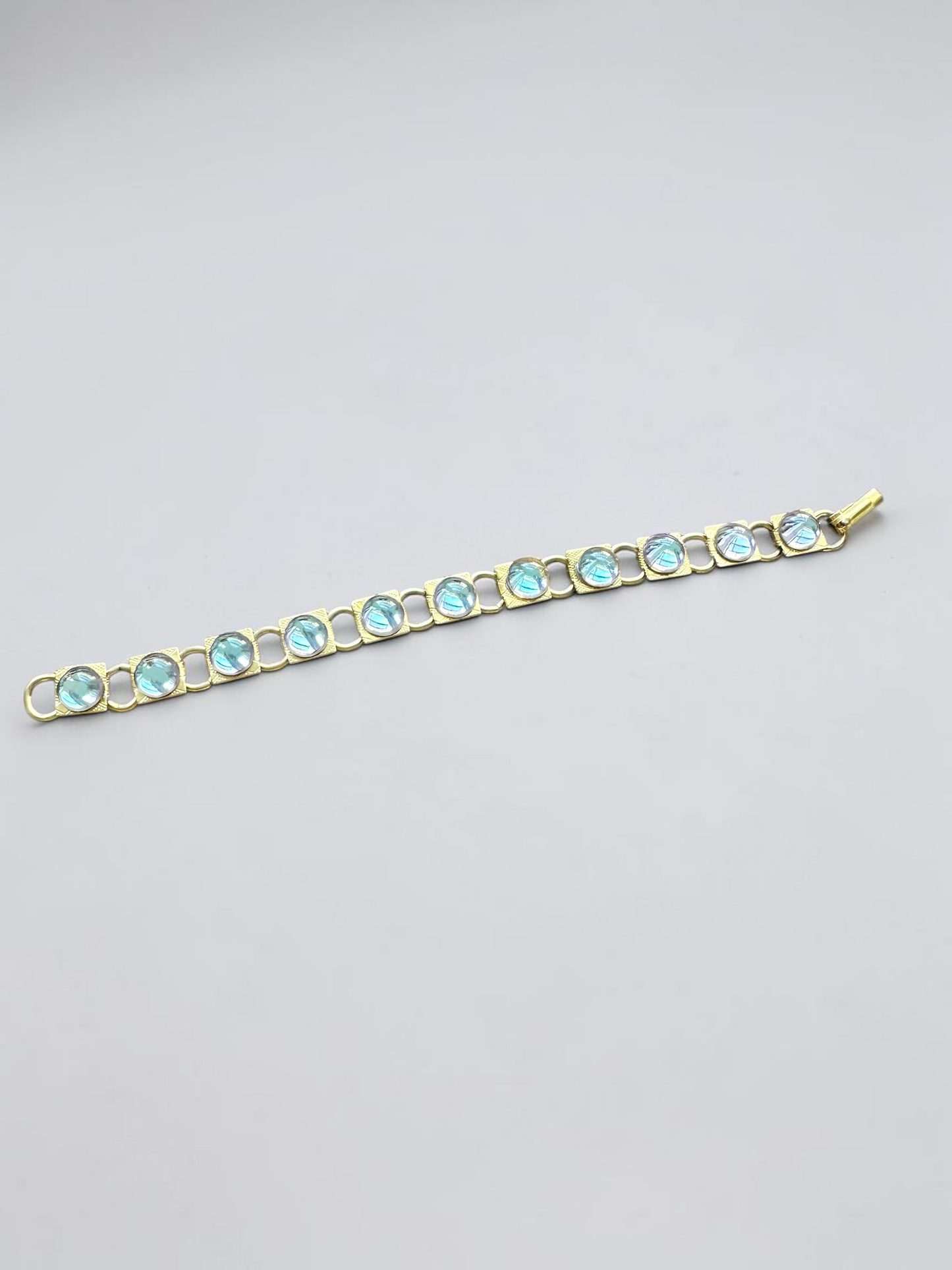 Vintage aqua glass cabochon gold tone link bracelet, laid flat