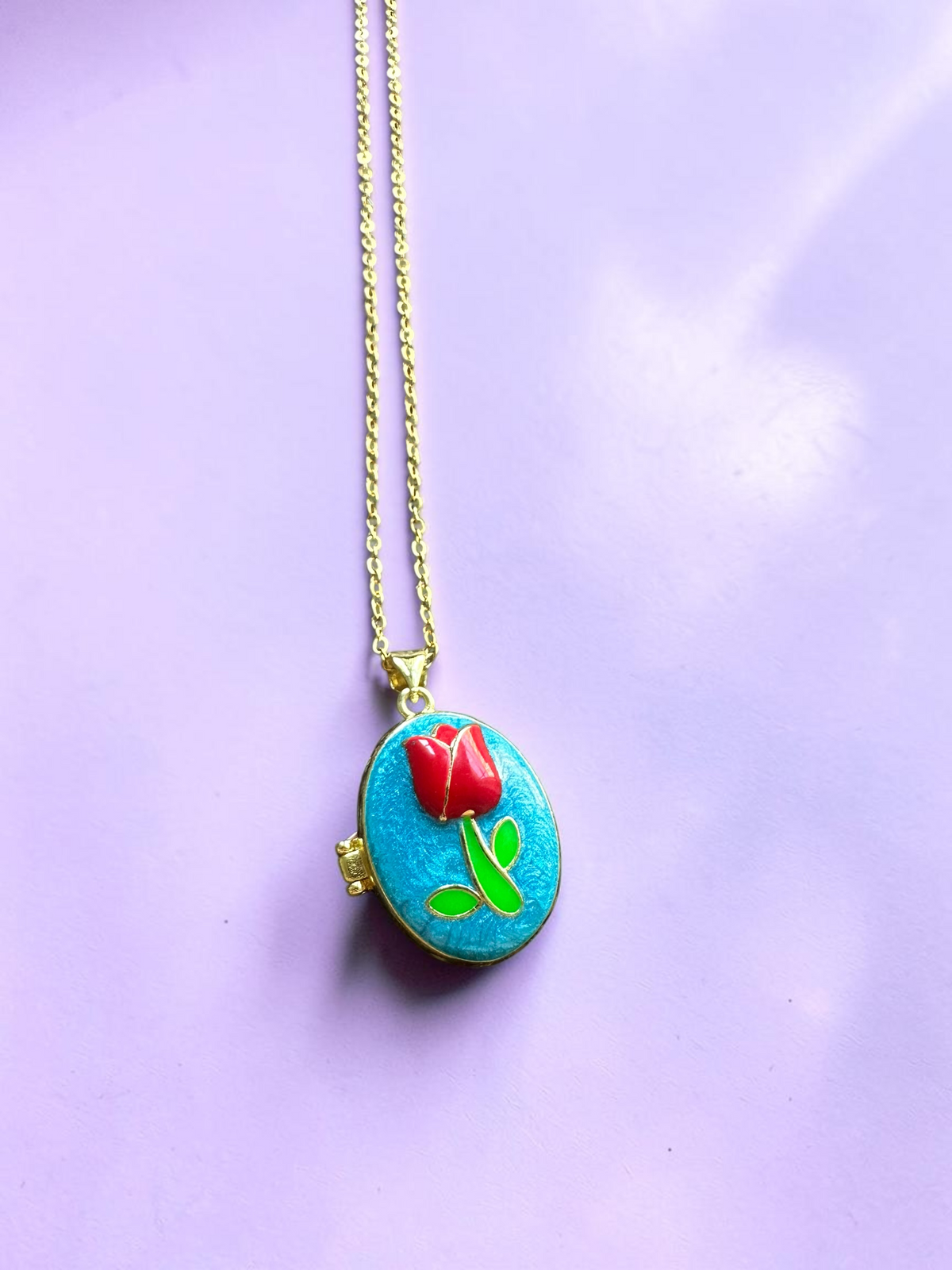 Enamel tulip locket necklace, front view on purple background