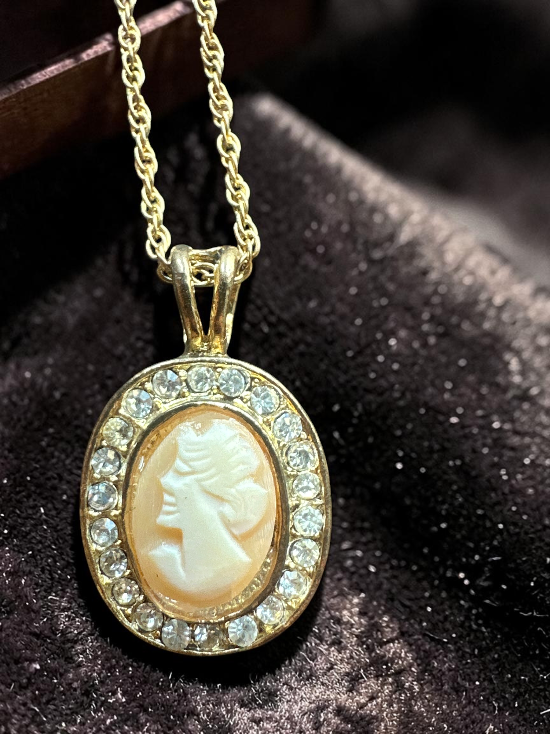 Vintage real cameo crystal halo gold tone necklace, close-up on dark velvet