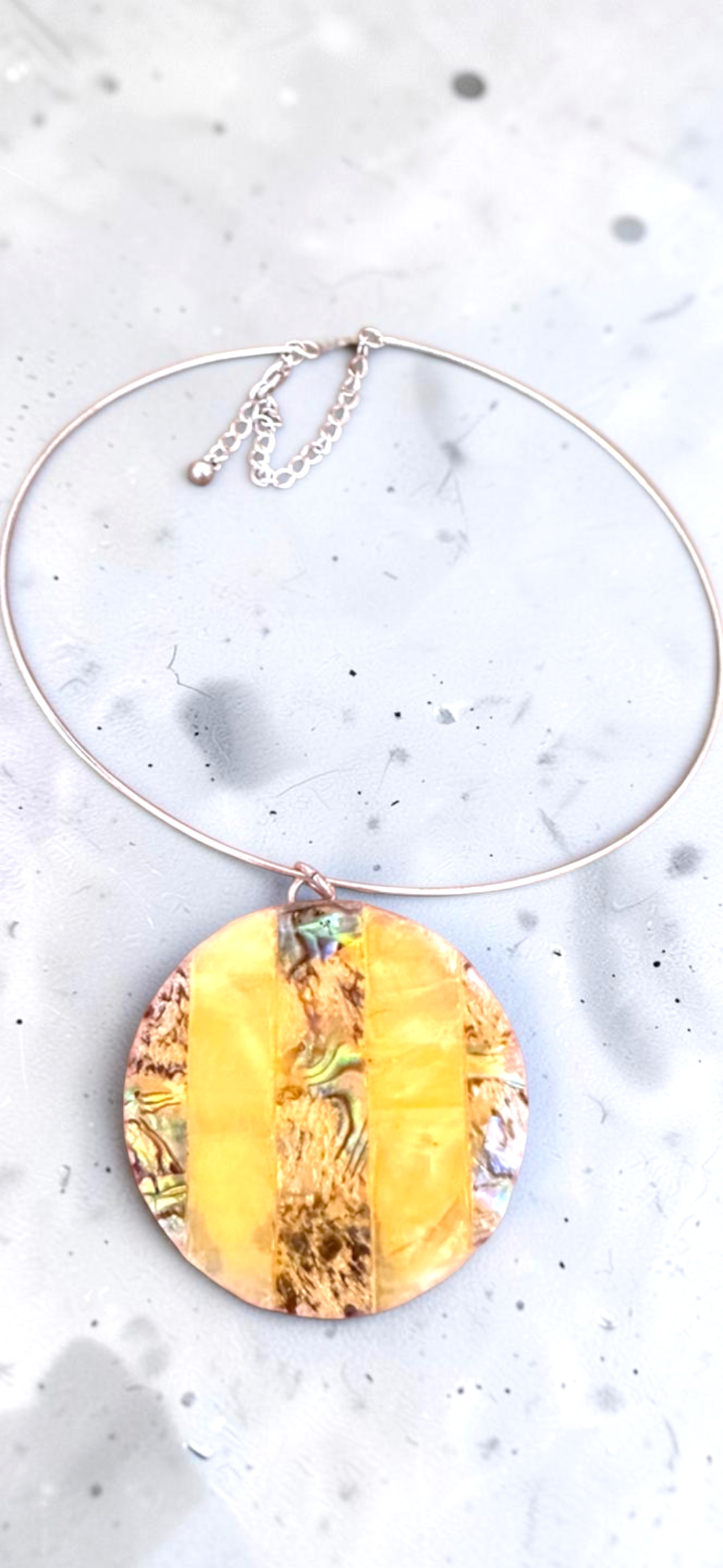 Yellow abalone shell disc choker necklace, full view on marble