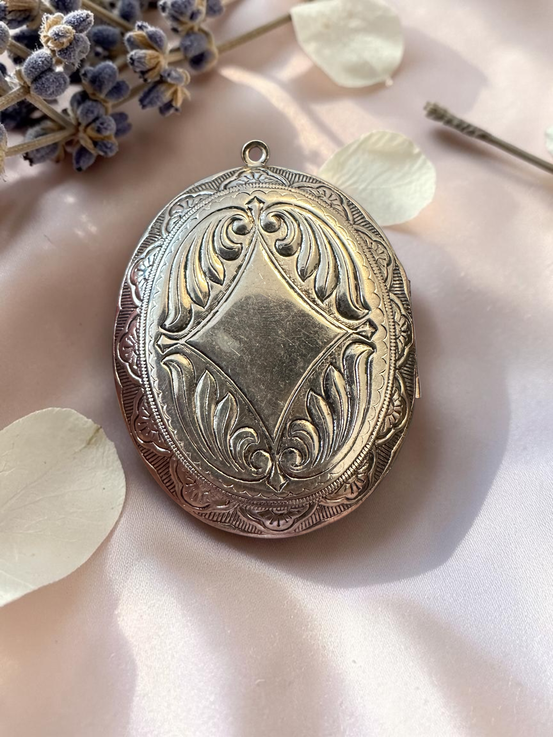 Engraved silver-tone locket reverse with intricate scrollwork detailing