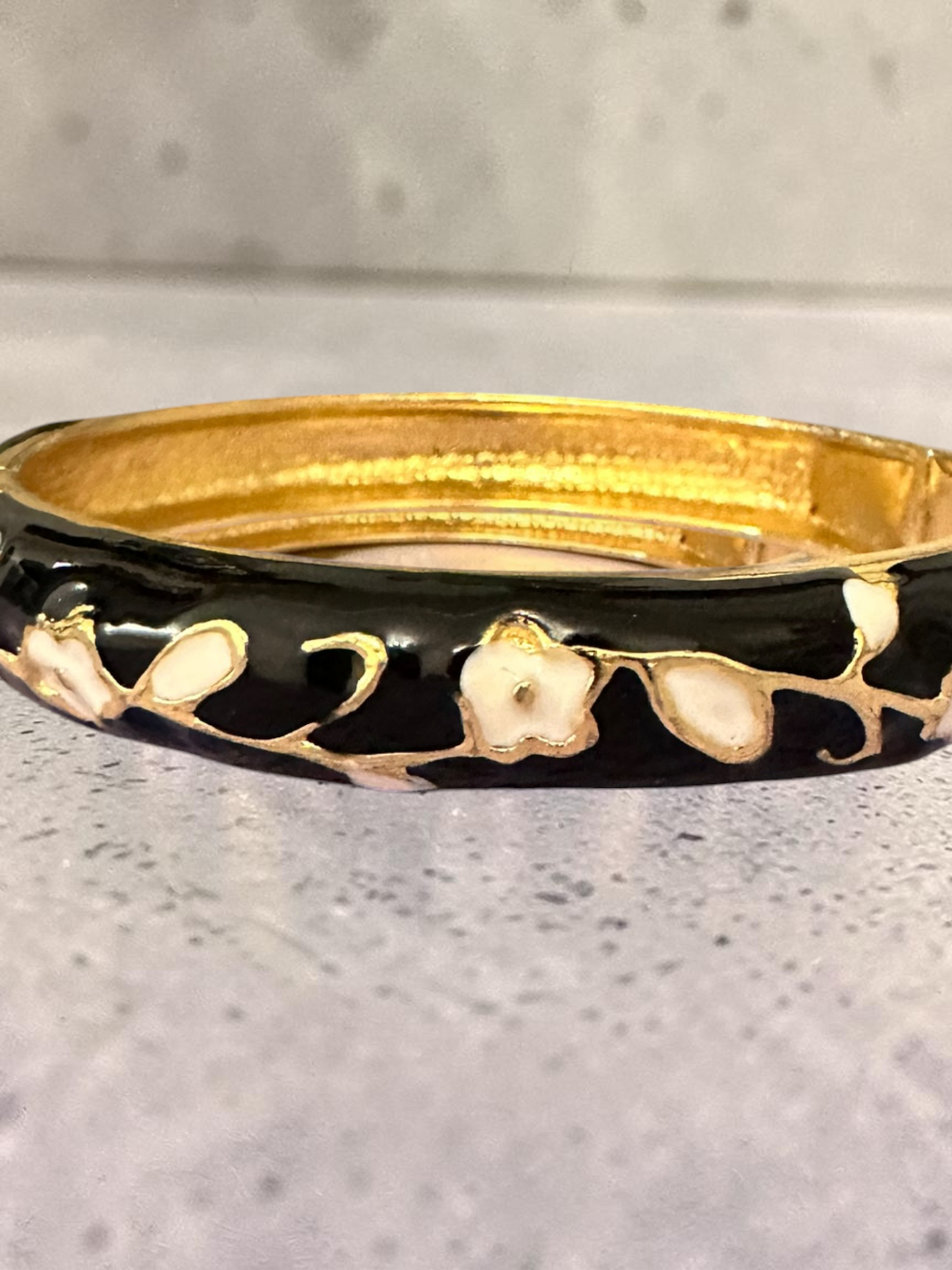 Black enamel floral bangle flat lay